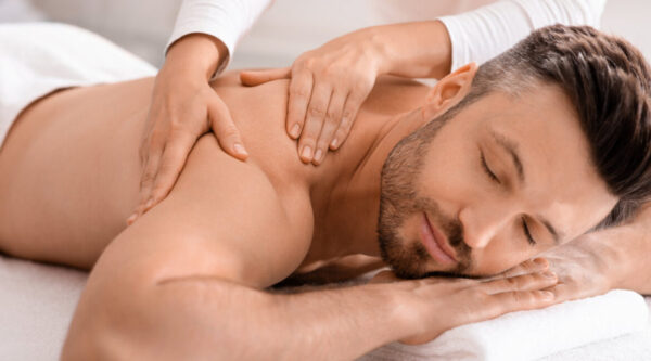 Closeup of handsome man having full body massage at spa